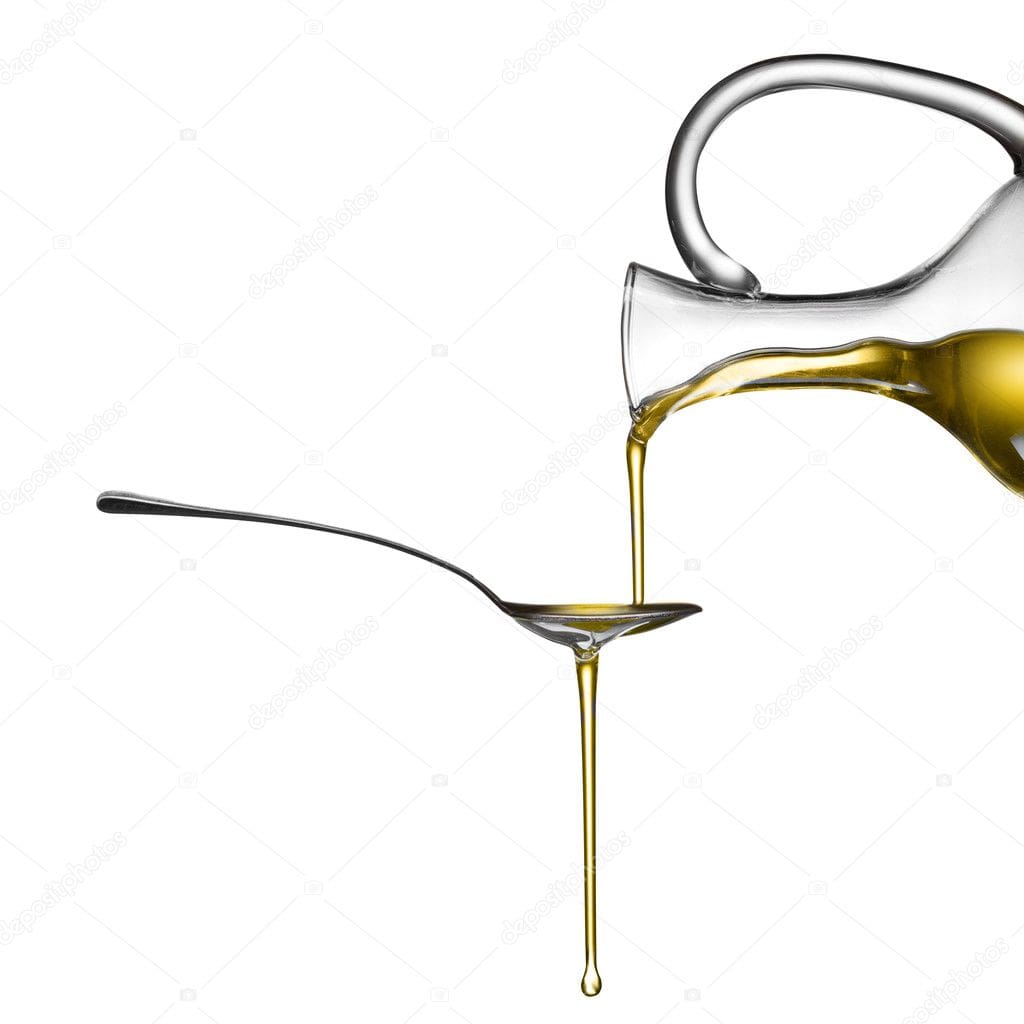 Olive oil being poured from a glass bottle into a spoon.