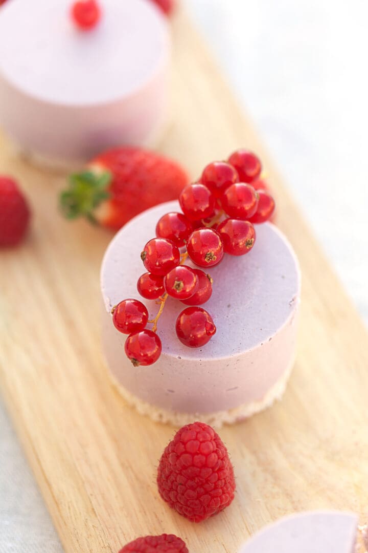 Elegant mousse cake topped with red currants and raspberries.